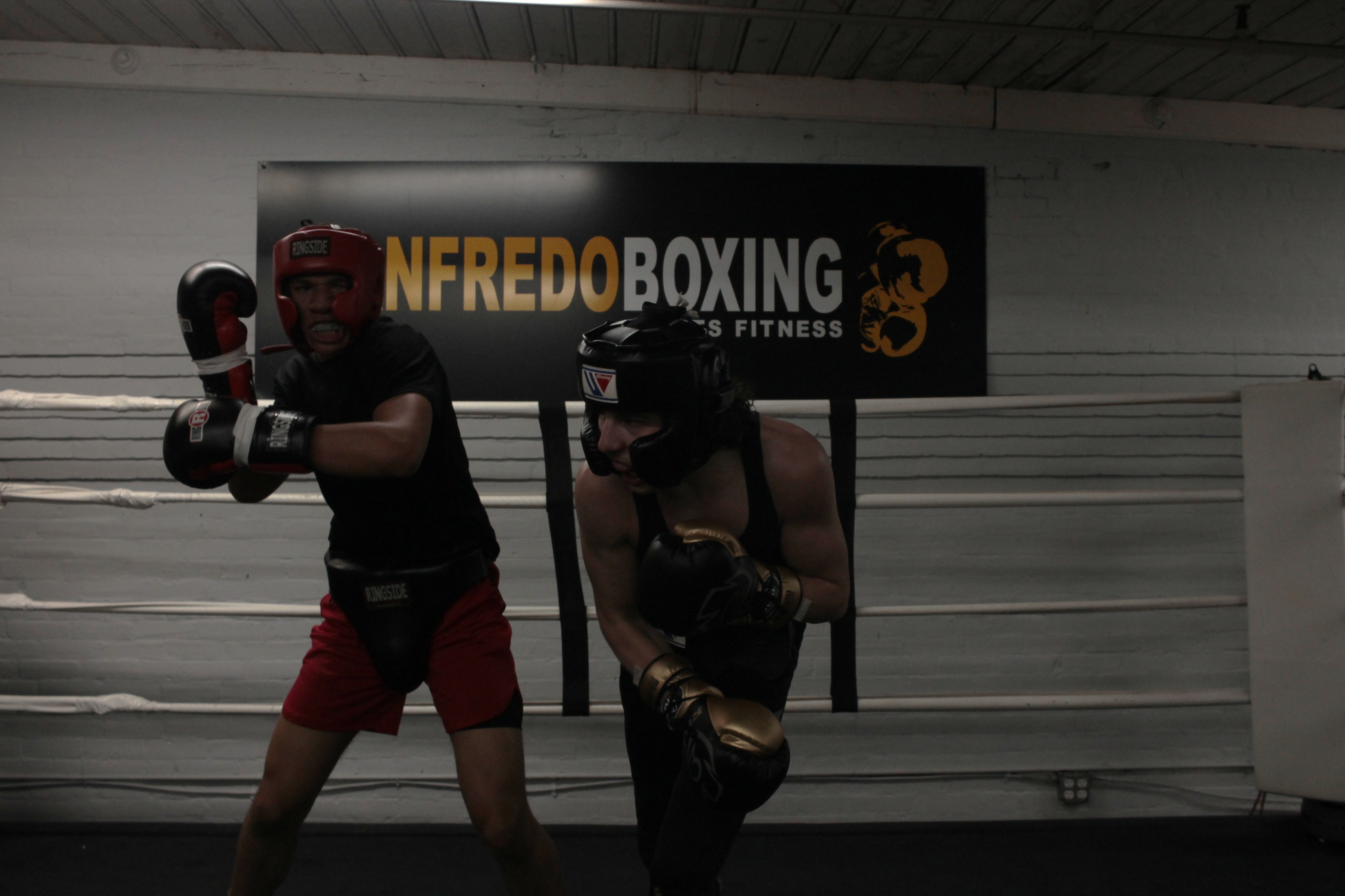 Two fighters sparring in the ring at Manfredo Boxing